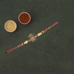 Elegant Metal Kalash Rakhi with red and golden beads